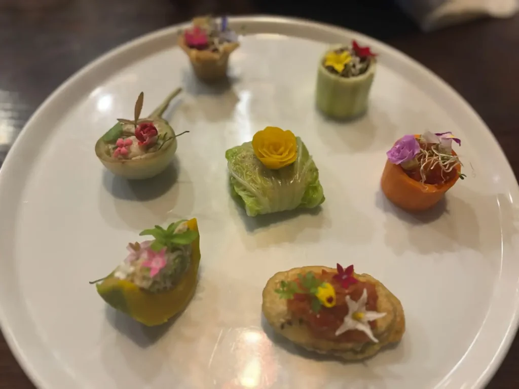 花とナスを組み合わせた一口前菜。伝統的なミアンカムをモダンに再構築した創作料理。