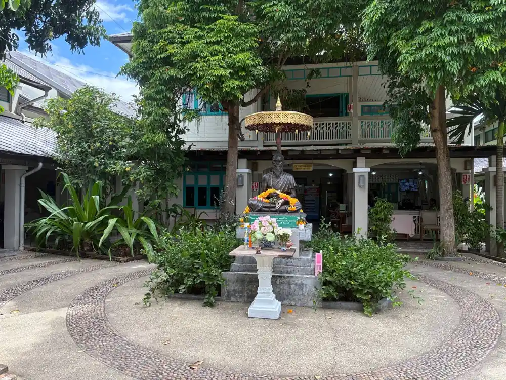 チェンマイ伝統医療センター（TTCM）の中庭と建物外観。仏像と緑に囲まれた落ち着いた雰囲気。